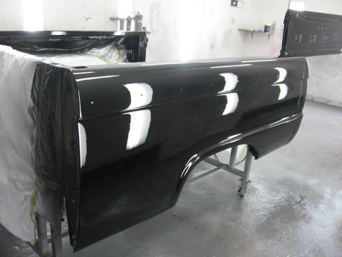 1966 Ford F-100 - Newly painted black bed and tailgate of a 1966 Ford F-100 pickup truck in a body shop.