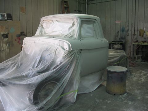 1966 Ford F-100 - A truck is covered in plastic in a garage, ready for a paint job. The vehicle is mostly obscured by protective sheeting.