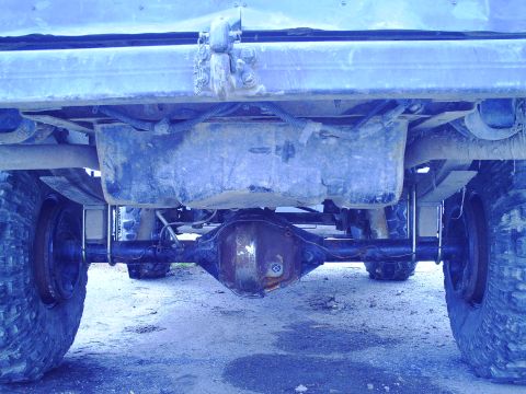 1990 Ford Bronco - Underside view of a truck's rear axle, fuel tank, and suspension components.