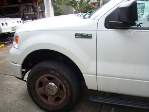 2006 Ford F-150 - Front quarter view of a white Ford F-150 pickup truck, highlighting the fender and wheel.