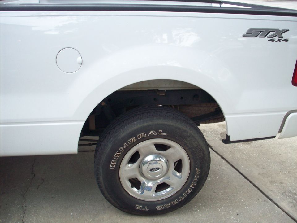 White Ford F-150 STX 4x4 pickup truck rear wheel well with a General Ameritrac TR tire