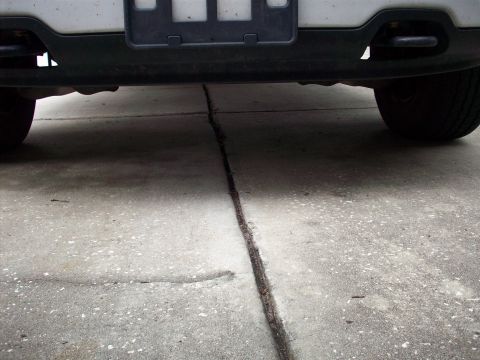 2006 Ford F-150 - Rear bumper and tires of a vehicle parked on a cracked concrete surface.