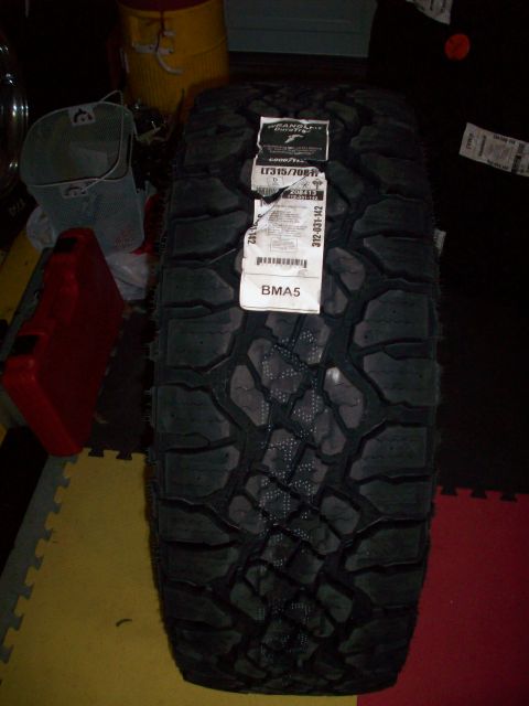 2006 Ford F-150 - A new Goodyear Wrangler tire with a size of LT315/70R17 is displayed indoors.