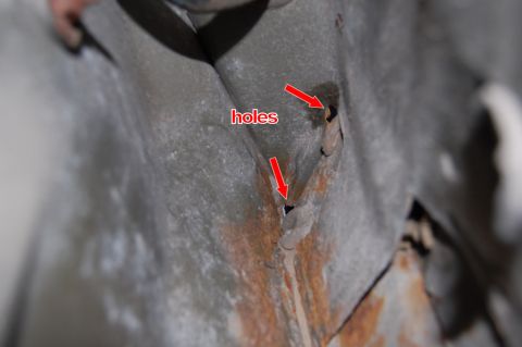 1985 Mercury Grand Marquis - Close-up view of corroded metal showing holes, with red arrows indicating the damage.
