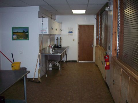 1985 Ford Bronco - This utility room contains a large sink, coffee maker, and various cleaning tools, along with a fire extinguisher mounted on the wall.
