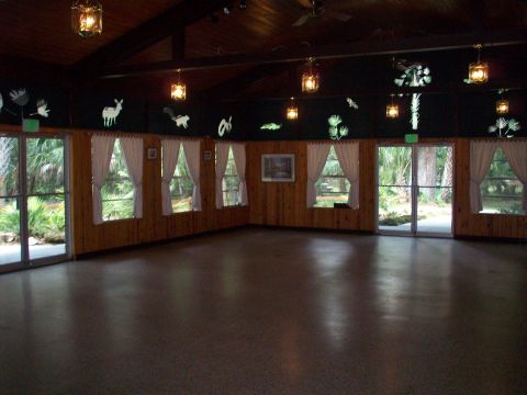 1985 Ford Bronco - This room features wood-paneled walls, large windows with white curtains, and decorative cutouts of animals and plants.