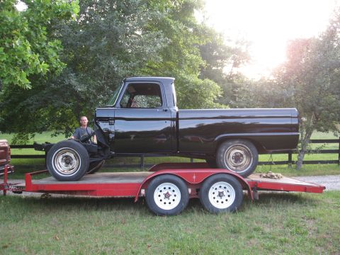 1966 Ford F-100 - Black 1966 Ford F-100 pickup truck being transported on a trailer.