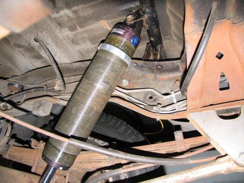 1984 Ford Bronco - Close-up of a vehicle's rear suspension components, including a shock absorber and leaf springs.