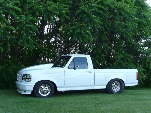 1994 Ford F-150 - This pickup truck has a custom hood and drag racing tires, suggesting performance modifications.