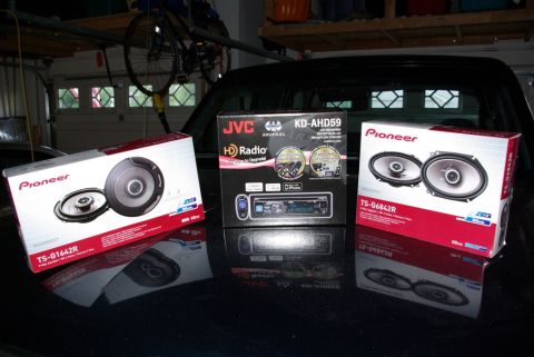 1995 Ford Bronco - Boxes of Pioneer speakers and a JVC HD Radio receiver are displayed on a car's surface.