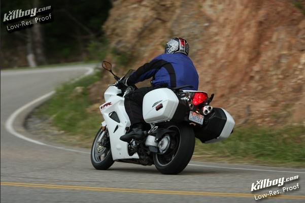 White motorcycle with saddlebags on a winding road