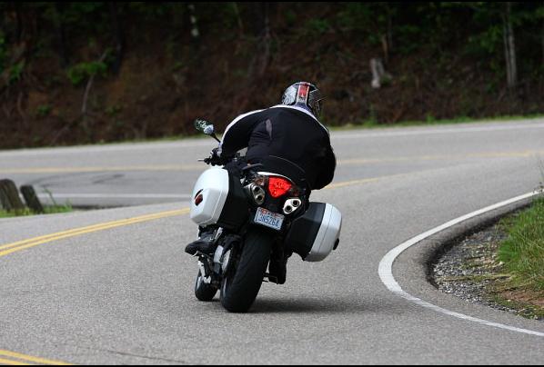 Motorcycle with saddlebags riding on a two-lane road with yellow lines