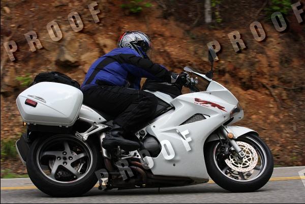White motorcycle with saddlebags in motion on a road