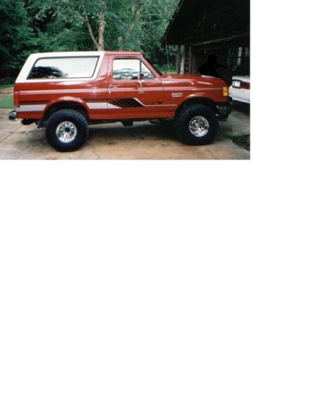 1987 Ford Bronco - This red 1987 Ford Bronco features a white removable top and is shown from the side.