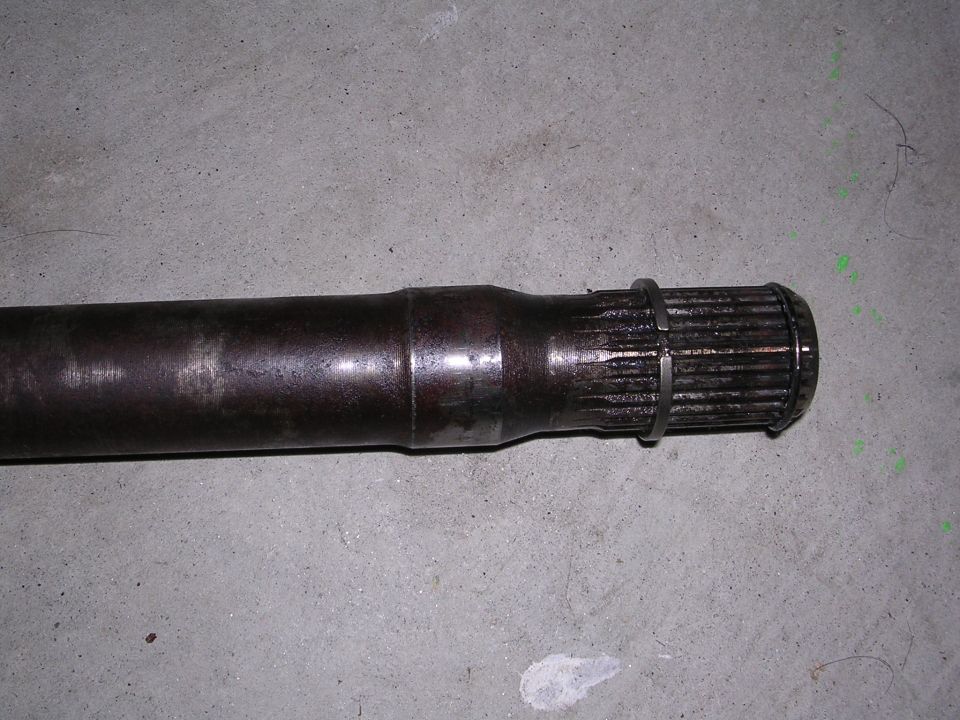 Driveshaft part with splines and a retaining ring on a concrete floor