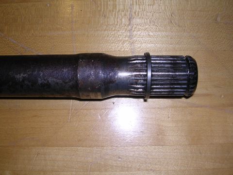 1983 Ferrari Enzo - A close-up view of a metal driveshaft component, showing its splined end and a retaining ring.