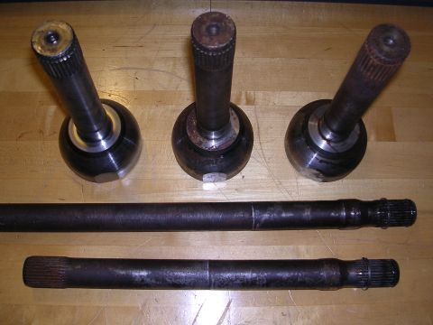 1983 Ferrari Enzo - Several CV joints and drive axles are shown on a wooden table.