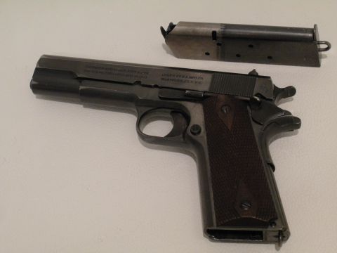 1996 Ford Bronco - A close-up view of a Colt 1911 pistol and its detached magazine.