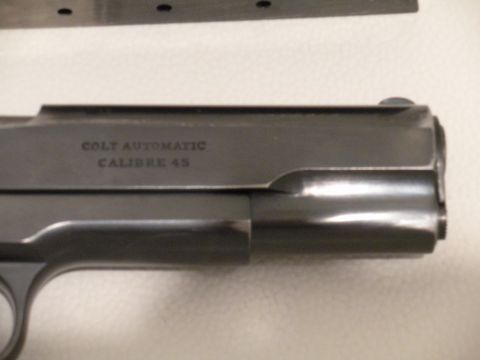 1996 Ford Bronco - Close-up of a Colt Automatic Calibre 45 pistol slide, with Supermotors.net logo visible.