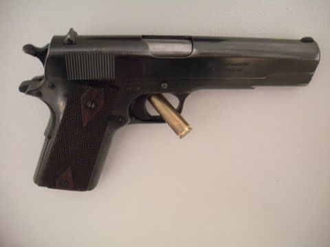 1996 Ford Bronco - A close-up view of a Colt M1911 pistol, showing a brass casing lodged in the ejection port.
