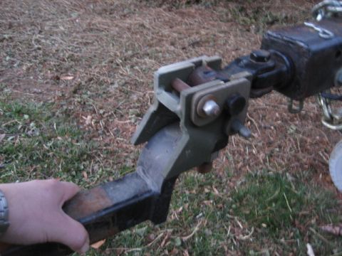 1996 Ford Bronco - Close-up of a trailer hitch receiver and coupler mechanism, held by a hand.