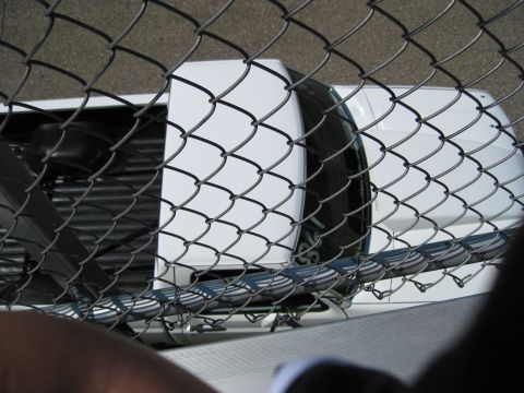 1994 Ford F-150 - A white pickup truck is viewed from an elevated angle, behind a chain-link fence.