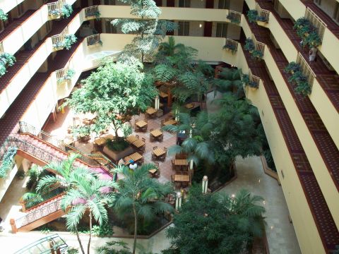 1985 Ford Bronco - A multi-story hotel atrium filled with greenery and balconies, seating areas on the ground floor.