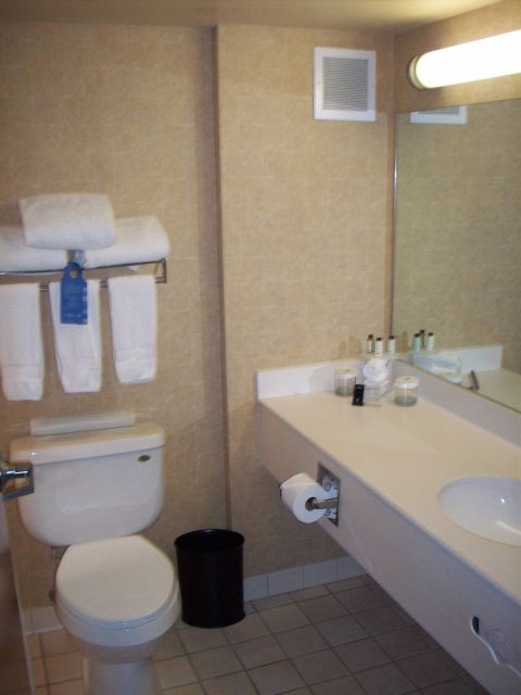 1985 Ford Bronco - This hotel bathroom features a toilet, sink, and towels on a rack.