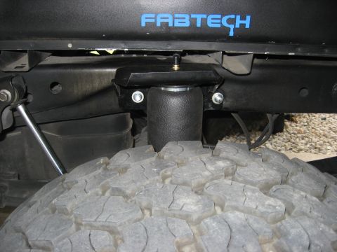 1979 Ford Bronco - Close-up of a Fabtech air suspension component installed above a large tire.
