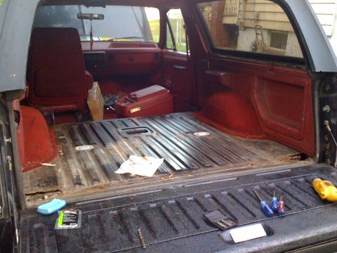 1988 Ford Bronco - The cargo area of an SUV is shown with tools laid out on the tailgate, ready for work.