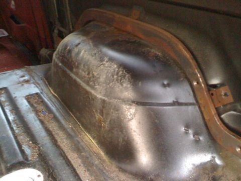 1988 Ford Bronco - Close-up view of the interior of a vehicle's wheel well, showing signs of rust and damage.