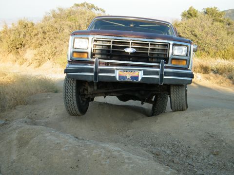 1982 Ford Bronco - Front view of a brown Ford Bronco driving on a dirt road, displaying an Arizona license plate.