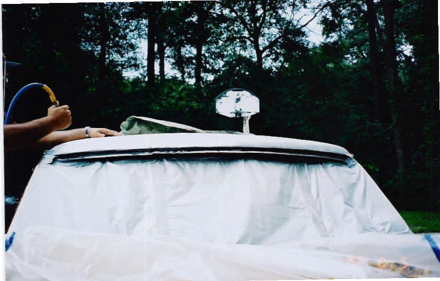 Vehicle top covered in plastic, being prepped for paint