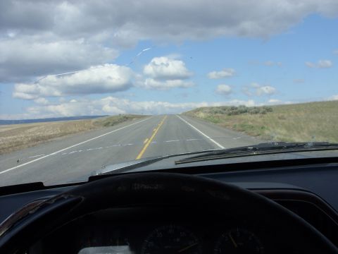 1988 Ford Bronco - Driving down a long, empty highway with rolling hills on either side.