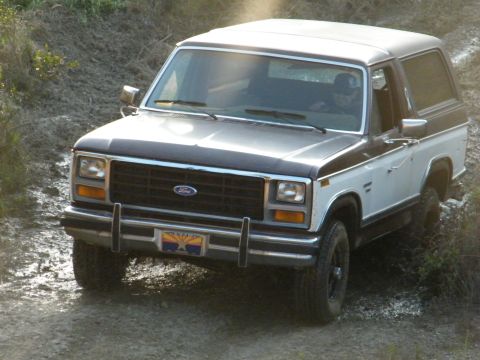 1982 Ford Bronco - 1982 Ford Bronco navigates a muddy, off-road trail.