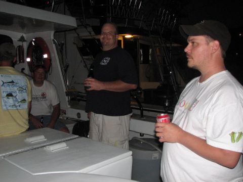 1979 Ford F-150 - Several men are gathered on a boat, some holding beverages, during what appears to be an evening outing.