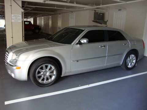 2008 Chrysler 300 - Silver 2008 Chrysler 300 sedan parked in a garage with a red SUV in the background.