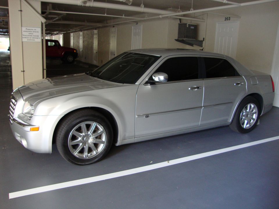 Silver 2008 Chrysler 300 sedan parked in a garage, red SUV visible in background