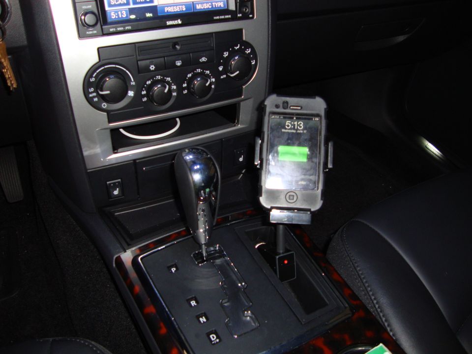 Car's center console with gear shifter, radio, and an iPhone mounted on a stand