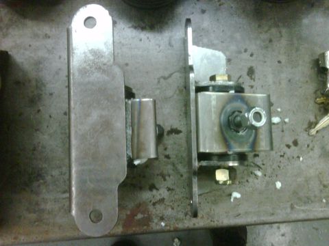 1996 Ford Bronco - Close-up of two fabricated motor mounts, showing welded seams and hardware.