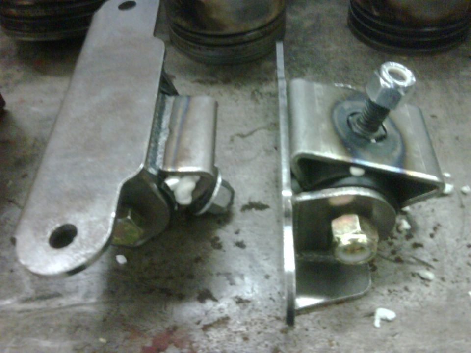 Two metal motor mounts with bolts and rubber bushings