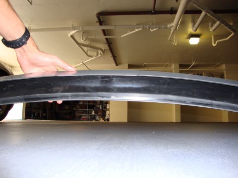 2008 Chrysler 300 - A person is holding a car's bumper trim piece in what appears to be a garage or parking structure.
