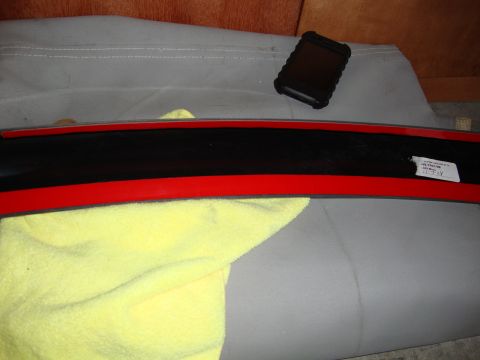 2008 Chrysler 300 - A black rear lip spoiler with red trim is shown with a yellow towel and a label with text.