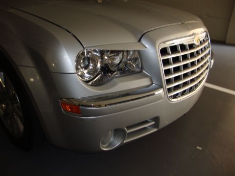 2008 Chrysler 300 - Close-up of a silver Chrysler 300's front grille and headlights, showing the distinctive body style.
