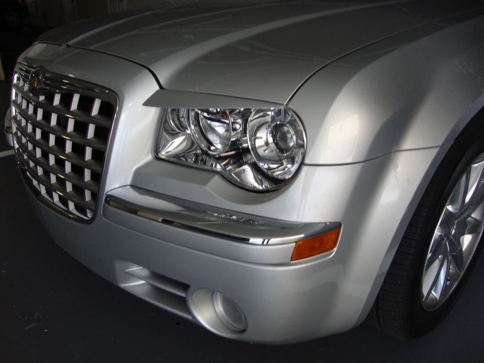 Silver Chrysler 300 front corner showing crosshair grille and headlight