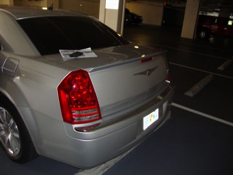 2008 Chrysler 300 - The rear of a silver sedan is visible, parked in a garage with a spoiler and a license plate.