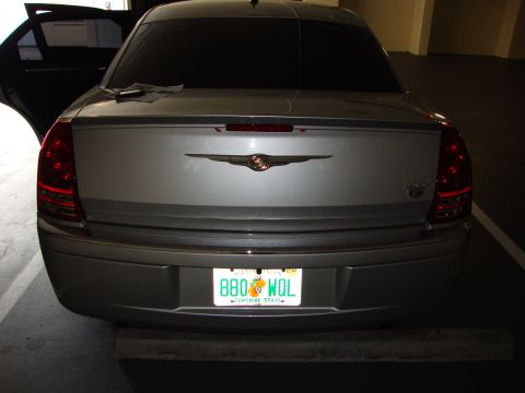 2008 Chrysler 300 - The rear of a silver Chrysler 300 sedan is visible, with its trunk open and license plate illuminated.