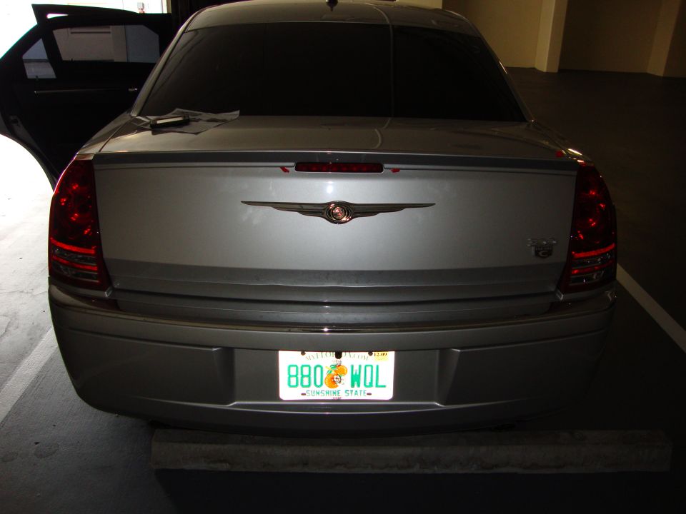 Rear of silver Chrysler 300 sedan in parking garage with Florida plate and lip spoiler