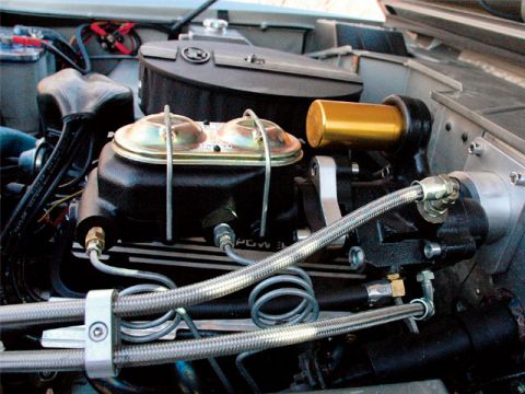 1979 Ford Bronco - Close-up view of a brake master cylinder with a gold-colored reservoir, part of an engine bay.