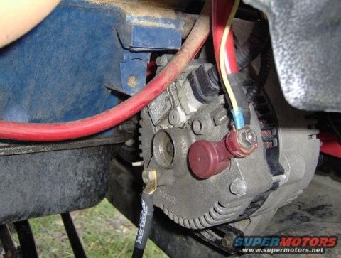 1979 Ford Bronco - Close-up of a vehicle's alternator and associated wiring, showing electrical connections.